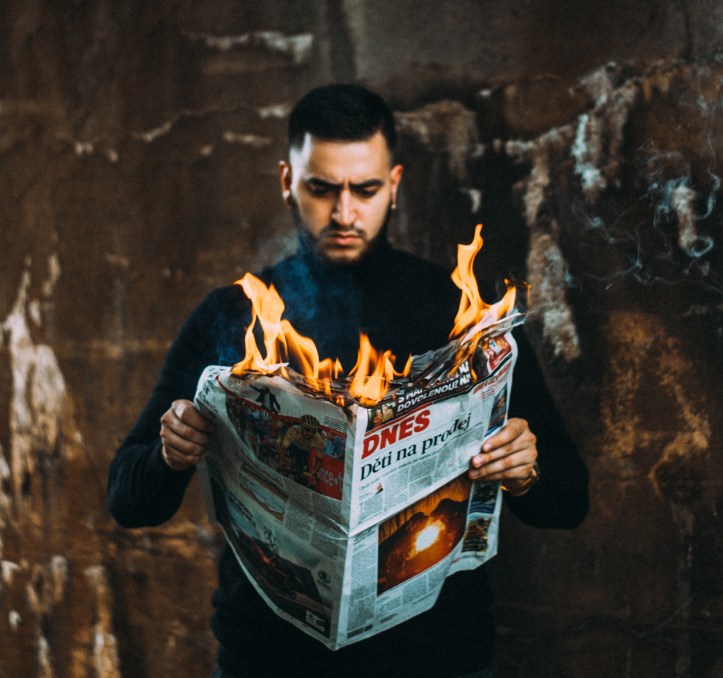 Ragazzo che tiene in mano un giornale in fiamme - Miti sul disturbo bipolare